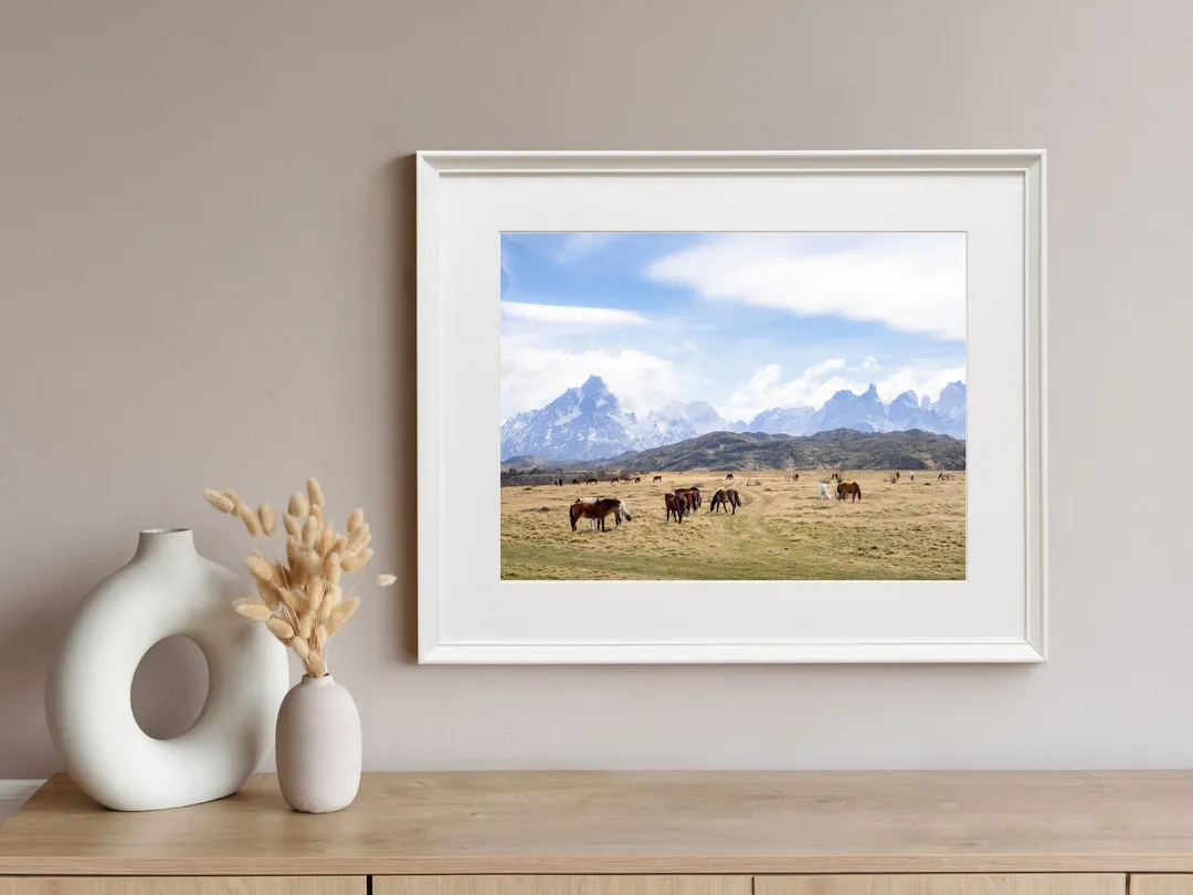 Fotografía Paisaje patagónico I enmarcada sobre un aparador de madera, junto a jarrones blancos
