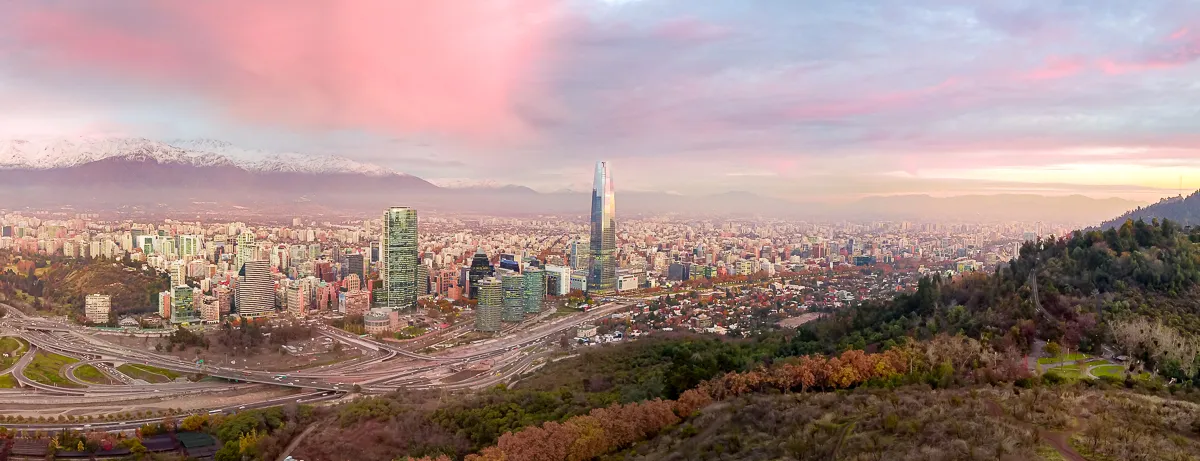 Santiago de Chile con la Gran Torre Santiago y la cordillera nevada de los Andes bajo nubes rosadas